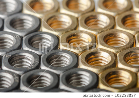 Metallic hex nuts layed out in a hexagonal pattern 102258857