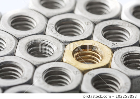 Metallic hex nuts layed out in a hexagonal pattern 102258858