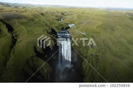 Aerial drone photo of Skogafoss waterfall along Iceland's Ring Road in the summer.	 102258938