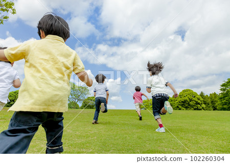 在清新的綠色公園裡奔跑的孩子們的後視 102260304