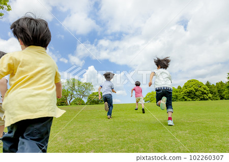 在清新的綠色公園裡奔跑的孩子們的後視 102260307