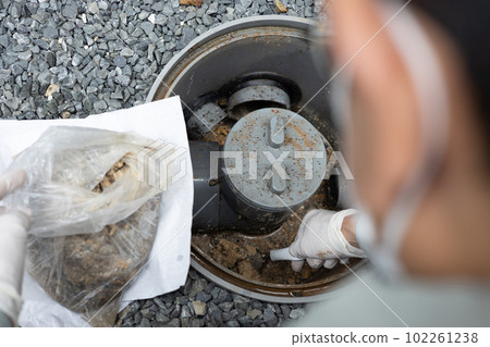 Cleaning a cesspool outside a detached house Cleaning a cesspool outside a detached house 102261238