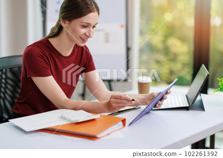 Concept of business office woman working,Businesswoman smile while working about her invesment plan with analyzing document and business investment graph data by using laptop on desk in workstation. Concept of business office woman working,Businesswoman smile while working about her invesment plan with analyzing document and business investment graph data by using laptop on desk in workstation. 102261392