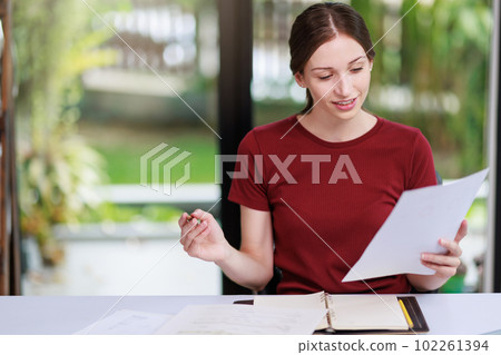 Concept of business office woman working,Businesswoman smile while working about her invesment plan with analyzing document and business investment graph data by using laptop on desk in workstation. Concept of business office woman working,Businesswoman smile while working about her invesment plan with analyzing document and business investment graph data by using laptop on desk in workstation. 102261394