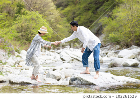 A couple enjoying playing in the river 102261529