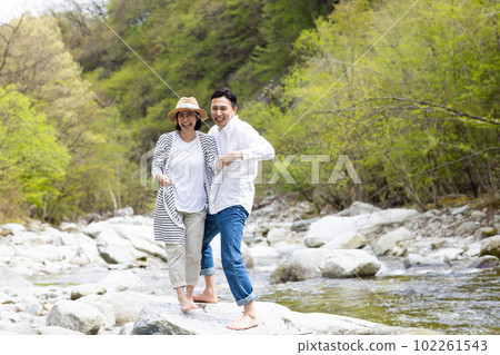 A couple enjoying playing in the river 102261543
