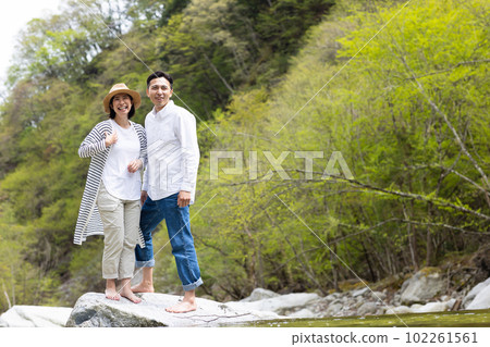 A couple enjoying playing in the river 102261561