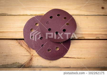 Round sandpaper discs for orbital sander. Wooden background Round sandpaper discs for orbital sander. Wooden background 102262175