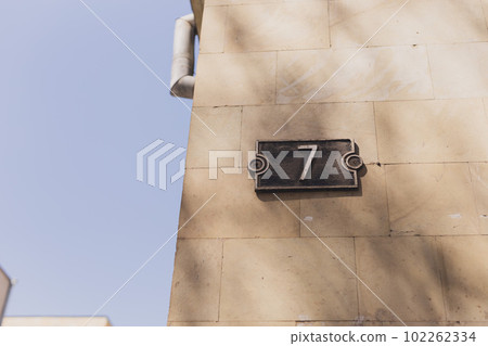 House number seven 7 sign on stone wall House number seven 7 sign on stone wall 102262334