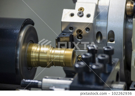 Close up scene the CNC lathe machine thread cutting at the end of brass pipe coupling parts. 102262936