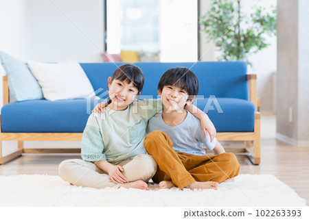Boys and girls relaxing in the living room 102263393
