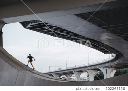 Parkour athlete climbs the bridge. Parkour athlete climbs the bridge. 102265138