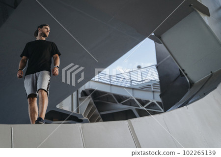 Portrait of freerunning athlete standing on the edge Portrait of freerunning athlete standing on the edge 102265139