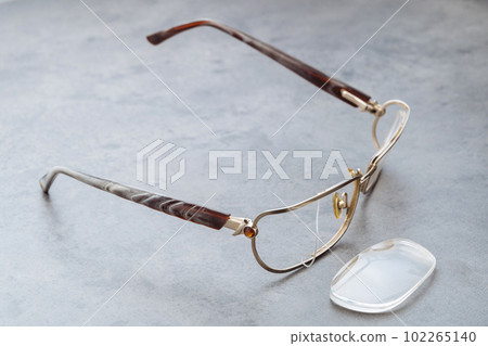 Damaged eyeglasses on table in optical shop waiting for repairing Damaged eyeglasses on table in optical shop waiting for repairing 102265140