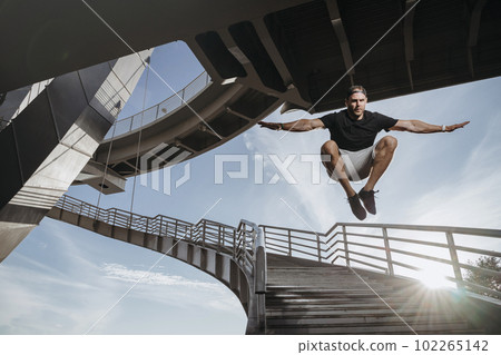 Freerunning athlete doing beautiful jump from bridge Freerunning athlete doing beautiful jump from bridge 102265142