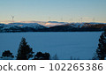 Lot of wind turbines on a snow-capped mountain in the evening at sunset 102265386