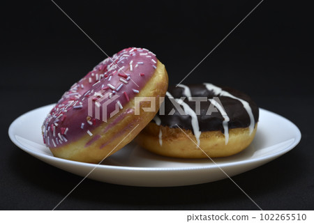 Delicious sweet donuts on a plate. Glazed doughnuts. Delicious sweet donuts on a plate. Glazed doughnuts. 102265510
