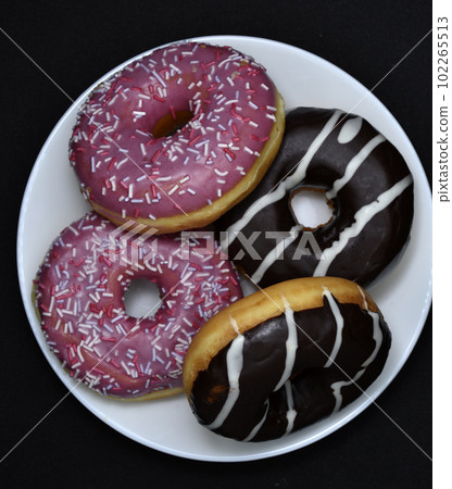 Delicious sweet donuts on a plate. Glazed doughnuts. Delicious sweet donuts on a plate. Glazed doughnuts. 102265513