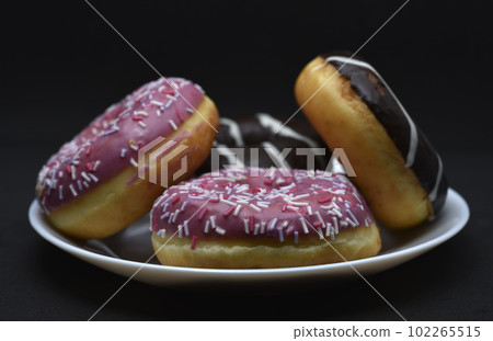 Delicious sweet donuts on a plate. Glazed doughnuts. Delicious sweet donuts on a plate. Glazed doughnuts. 102265515