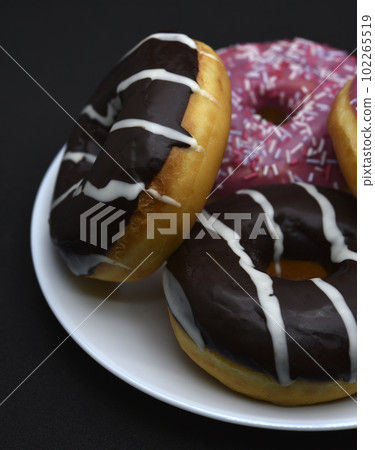 Delicious sweet donuts on a plate. Glazed doughnuts. Delicious sweet donuts on a plate. Glazed doughnuts. 102265519
