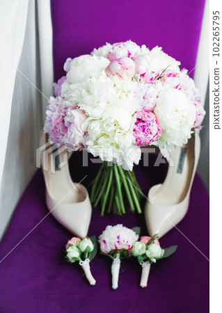 Pair of elegant and stylish bridal shoes with a bouquet with roses and other flowers Pair of elegant and stylish bridal shoes with a bouquet with roses and other flowers 102265795