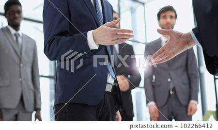 handshake of business partners against the background of colleag handshake of business partners against the background of colleag 102266412