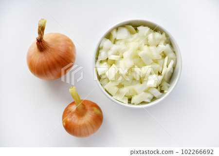 Two onions and chopped onion on a white plate. Onion on a white background. 102266692