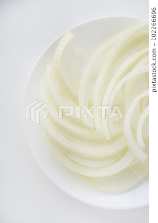 Chopped onion on a white plate. Fresh onion. Vegetables close-up. Chopped onion on a white plate. Fresh onion. Vegetables close-up. 102266696