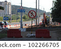 Construction work in the city in summer. Wide road repair. Warning road sign, barriers and excavator  102266705