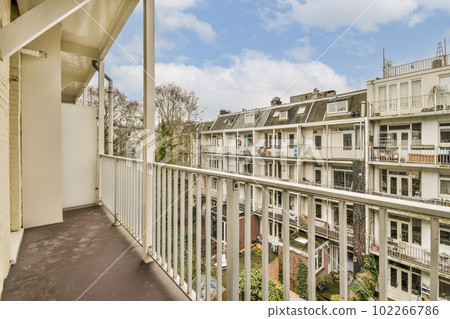 a balcony with some buildings in the background and blue sky above it, as seen from an apartment's balcony 102266786