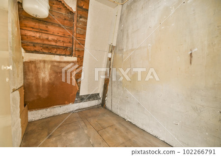 an unfinished bathroom with wood walls and white paint on the walls, which has been stripped down to make way for new flooring 102266791