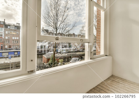 a window with some buildings in the background and a view of a canal from it's side, taken from inside 102266795