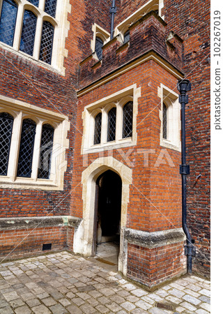 Arched rustic door in a stone wall at Hampton Court Palace 102267019