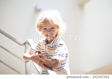 Little boy on stairs. Sunny staircase in new home. Little boy on stairs. Sunny staircase in new home. 102267263