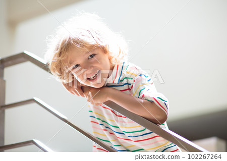 Little boy on stairs. Sunny staircase in new home. Little boy on stairs. Sunny staircase in new home. 102267264