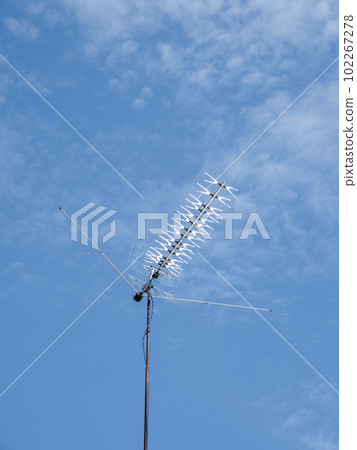 TV rooftop antenna on blue sky background. Industrial equipment used to receive internet signal, television connection and communication. 102267278