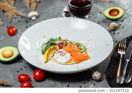 Summer healthy fastfood lunch, breakfast with Pancake with red fish, avocado and egg for breakfast. Aesthetic still life, healthy food concept Summer healthy fastfood lunch, breakfast with Pancake with red fish, avocado and egg for breakfast. Aesthetic still life, healthy food concept 102267518