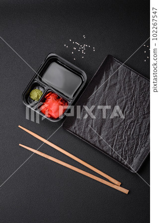 Pickled ginger, soy sauce and wasabi in portioned plastic containers Pickled ginger, soy sauce and wasabi in portioned plastic containers 102267547
