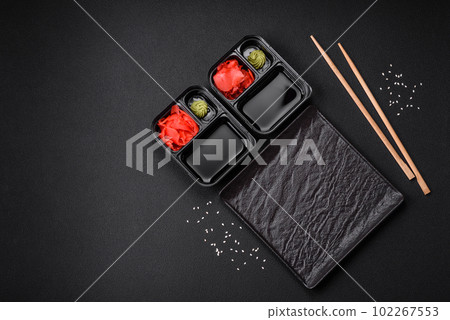 Pickled ginger, soy sauce and wasabi in portioned plastic containers 102267553