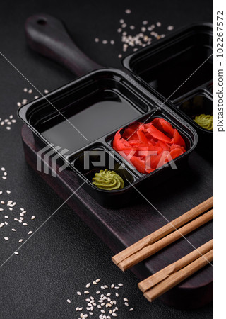 Pickled ginger, soy sauce and wasabi in portioned plastic containers 102267572