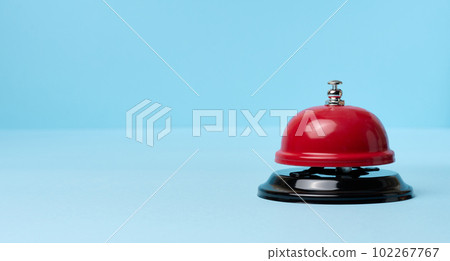 Metallic red bell to call staff on a blue background 102267767