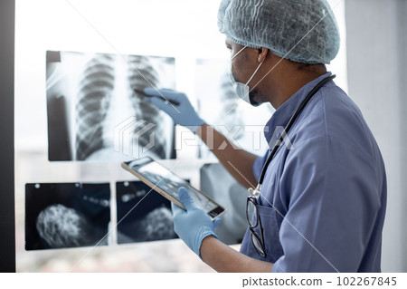 Chest X-ray studied by radiologist using tablet and stylus 102267845