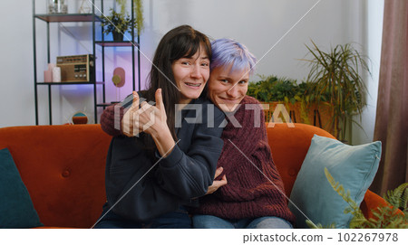 Happy lesbian women family couple showing thumbs up, like sign positive something good feedback home 102267978
