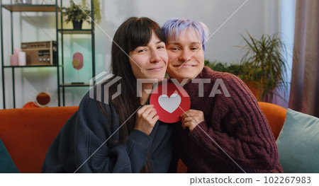 Lesbian women family couple or girls friends embracing holding heart shape from paper 102267983