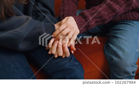 Close-up of two lesbian women family couple hold caressing hands together showing love to each other 102267984