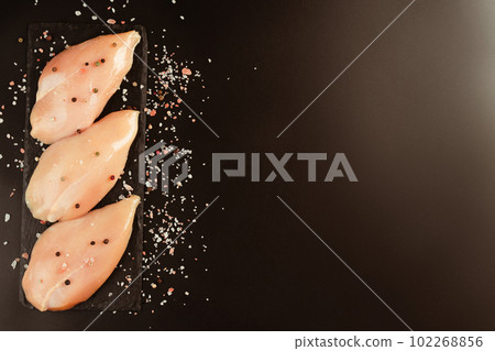 Raw fresh chicken fillet with fresh herbs on a black background.Copy space.Food for retail.Ogranic food,healthy eating.Food concept.Top view.Chicken breast Fillets.Close up.Raw chicken meat. Raw fresh chicken fillet with fresh herbs on a black background.Copy space.Food for retail.Ogranic food,healthy eating.Food concept.Top view.Chicken breast Fillets.Close up.Raw chicken meat. 102268856