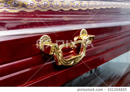 New wooden coffin with a handle made of yellow metal, 102268885