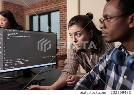 Tech enginner asking app designer for help with html code, pointing at database script on terminal window. Team of programming engineers working on app developing program in it agency. Tech enginner asking app designer for help with html code, pointing at database script on terminal window. Team of programming engineers working on app developing program in it agency. 102269428