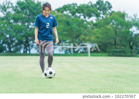 一名穿著制服在足球場上練習足球和五人制足球的日本女子 102270367