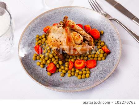 Roasted whole quail served on plate with peas and fried carrot Roasted whole quail served on plate with peas and fried carrot 102270762